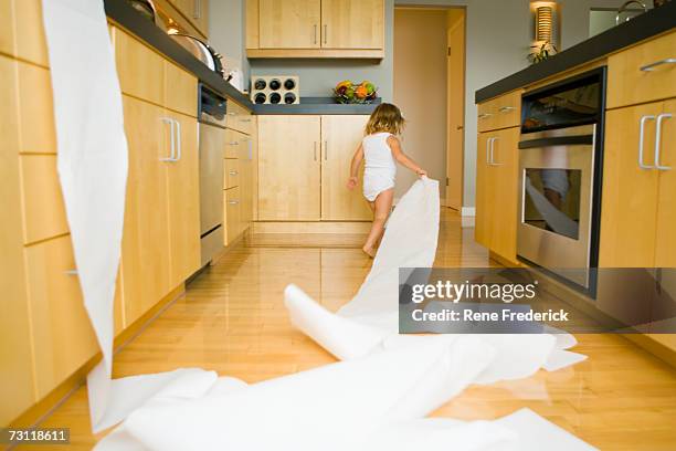 girl (2-4) spilling roll of paper towels across kitchen floor, rear view - scruffy stock pictures, royalty-free photos & images