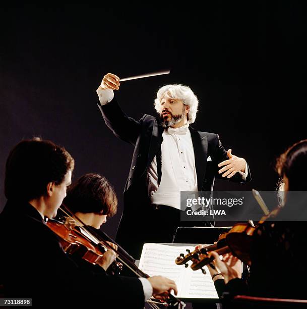 man conducting orchestra, view from violin section - dirigent stock-fotos und bilder