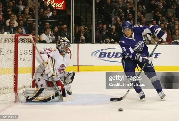 Western Conference All-Star Teemu Selanne of the Anaheim Ducks receives a pass near Eastern Conference All-Star goaltender Ryan Miller of the Buffalo...