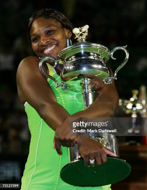 Serena Williams of the USA poses with the trophy after winning her women's final match against Maria Sharapova of Russia on day thirteen of the...