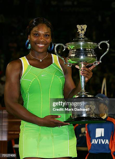 Serena Williams of the USA poses with the trophy after winning her women's final match against Maria Sharapova of Russia on day thirteen of the...