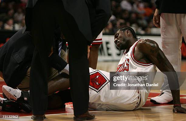 Ben Wallace of the Chicago Bulls grimices as team trainer Fred Tedeschi tends to Wallace's injured left knee against the Miami Heat January 27, 2007...