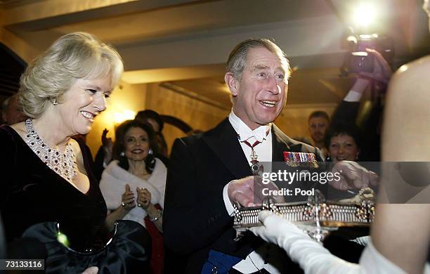 Britain's Prince Charles, Prince of Wales and Duchess of Cornwall Camilla Parker-Bowles receive a gift from Leonore Annenberg at the 150th Academy of...