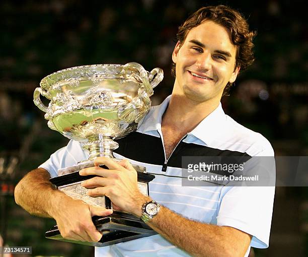 Roger Federer of Switzerland holds the trophy after winning his men's final match against Fernando Gonzalez of Chile on day fourteen of the...