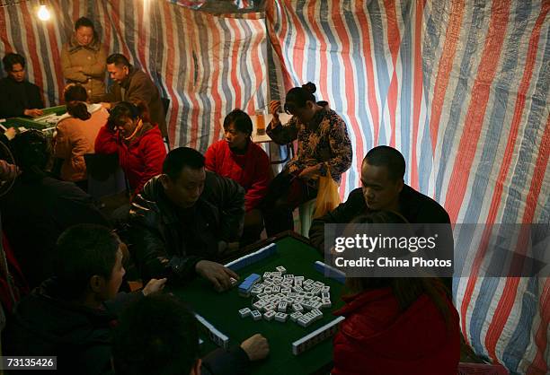 Residents play mah-jong at a shed outdoors in a yard at the Shibati Area on January 27, 2007 in Chongqing Municipality, China. The Shibati Area is a...