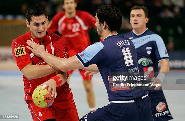 Patryk Kuchzynski of Poland competes against David Spiler of Slovenia during the Men's Handball World Championship Group I game between Slovenia and...