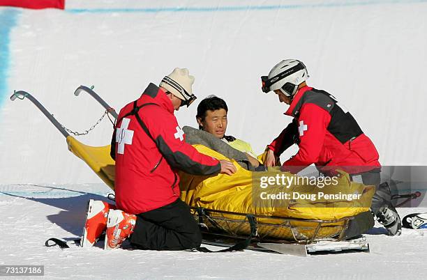 Hiroomi Takizawa of Japan is loaded onto a sled to be taken off the mountain by medical personnel after he crashed during the semifinals in the men's...
