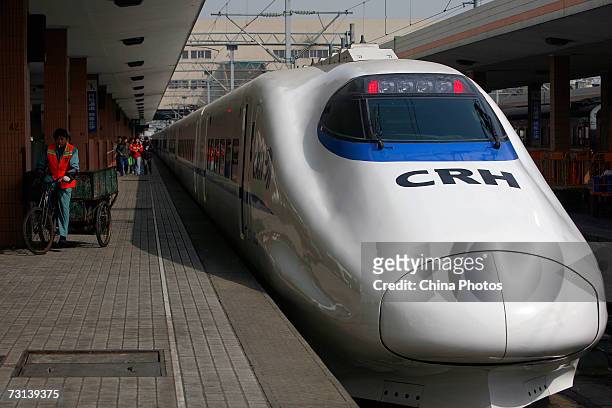 Worker pedals past a CRH "bullet train" at Hangzhou Railway Station January 28 in Hangzhou, Zhejiang Province, China. China's bullet train, the...