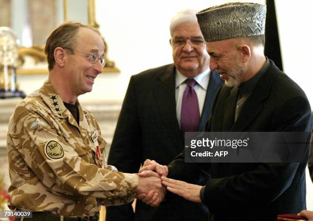 Afghan President Hamid Karzai shakes hands with Commander of NATO International Security Assistance Force British General David Richards at The...