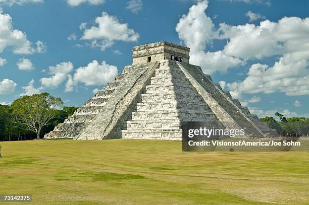 white puffy clouds over the mayan pyramid of kukulkan (also known as el castillo) and ruins at chichen itza, yucatan peninsula, mexico - mayan pyramid stock pictures, royalty-free photos & images