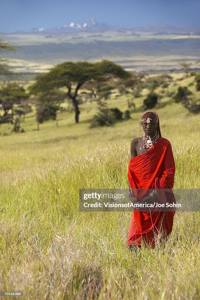 Masai Warrior in red surveying landscape of Lewa Conservancy, Kenya Africa