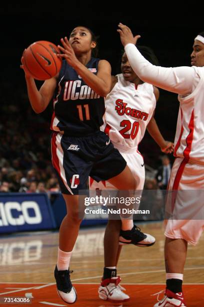 Ketia Swanier of the University of Connecticut Huskies shoots against Monique McLean of the St. John's University Red Storm at Madison Square Garden...
