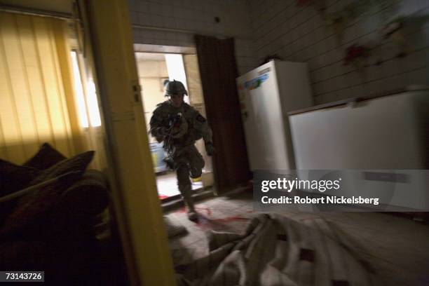 Army medic dashes from the kitchen area carrying a helmet in an abandoned apartment where SSGT Hector Leija, 27 years, was shot and critically...
