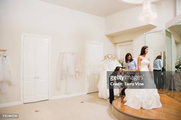 hispanic woman being fitted for wedding dresses - bridal shop stockfoto's en -beelden