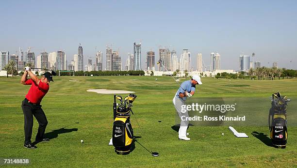 Paul Casey of England and Marc Warren of Scotland hits towards the Dubai skyline during media day at the Montgomerie Course prior to the Dubai Desert...