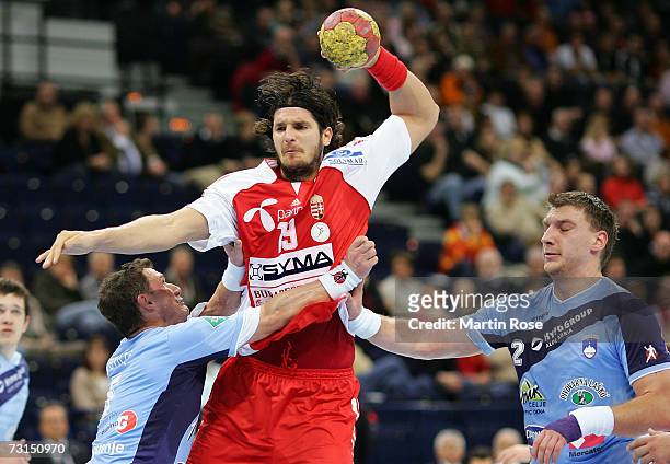 Laszlo Nagy of Hungary is attacked by Zoran Jovicic and Miladin Kozlina of Slovenia during the IHF World Championship Place 9 game between Slovenia...