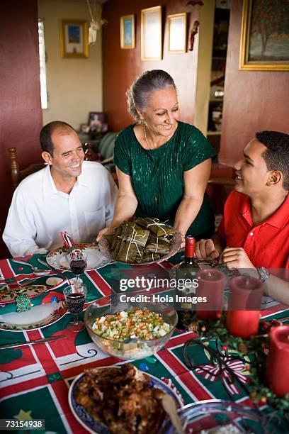 mature couple and their son at the dining table - dominican ethnicity stock pictures, royalty-free photos & images