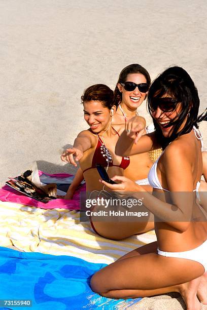 young women hanging out and sunbathing on beach - american sunbathing association photos et images de collection