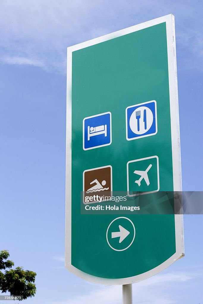 Freeway sign for airport, hotel, restaurant and beach, Spanish