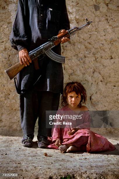 Khalil Rahman poses next to his daughter, Nasrine on the Pakistani border next to the " Angour Ada " passage on July, 2004 in Petawgai, Afghanistan.