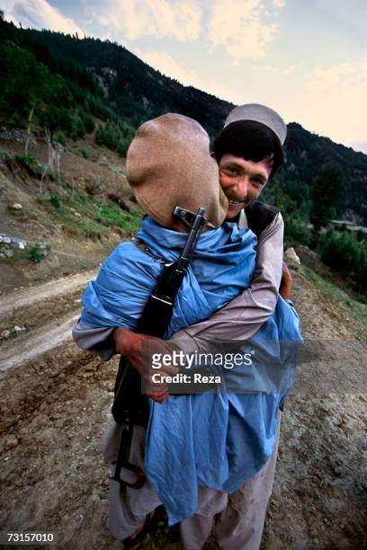 Two men embrace in a Shiite village on July, 2004 in Kalachi, Pakistan.