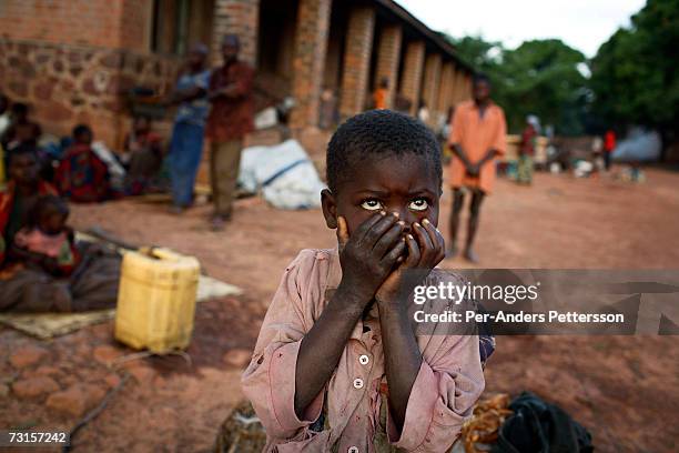 An unidentified boy covers his face as he is one of thousands of newly arrived refugees who gathered outside a military base on December 11, 2005 in...