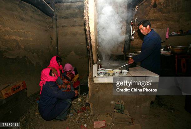 Relatives cook food during a Tu ethnic minority group wedding ceremony of Qi Xinghe and his bride Luo Jinhua on January 30, 2007 in Huzhu County of...