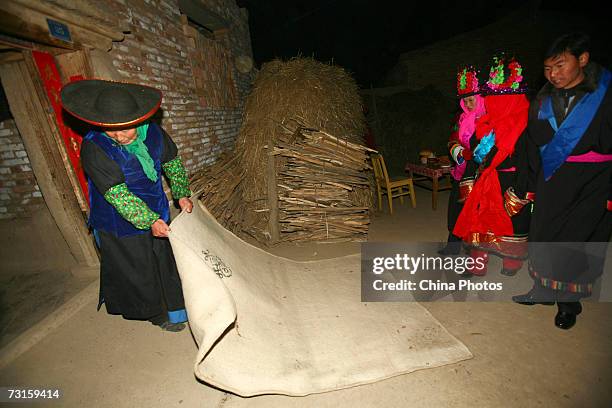 The groom Qi Xinghe leads bride Luo Jinhua to enter his home during a Tu ethnic minority group wedding ceremony on January 30, 2007 in Huzhu County...