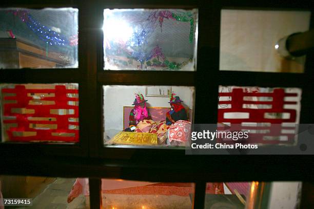 The groom Qi Xinghe and bride Luo Jinhua rest in the bridal chamber during a Tu ethnic minority group wedding ceremony on January 30, 2007 in Huzhu...