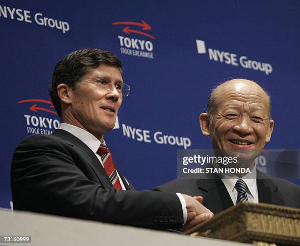 New York, UNITED STATES: NYSE Group, Inc. CEO John A. Thain shakes hands with Tokyo Stock Exchange, Inc. President & CEO Taizo Nishimuro after...