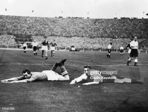 Ernst Happel and Nat Lofthouse sprawled on the pitch near the Austrian goal during an international match between England and Austria at Wembley...