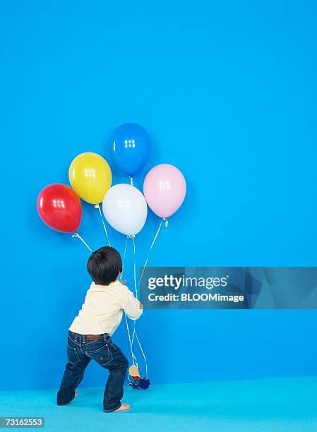 asian young boy playing with balloons - child balloon studio photos et images de collection