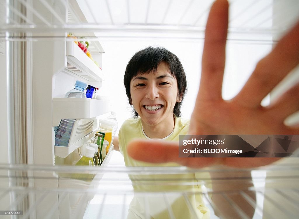 Man looking into fridge and reaching for something