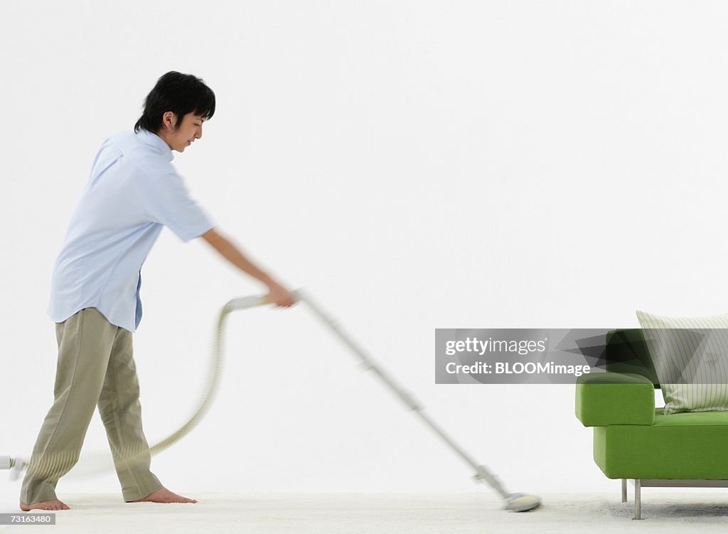 Man cleaning room with vacuum cleaner