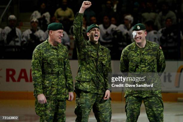 During a pre-game ceremony to honor the Canadian Military, members of the Canadian Armed Forces salute the cheering fans prior to the Vancouver...