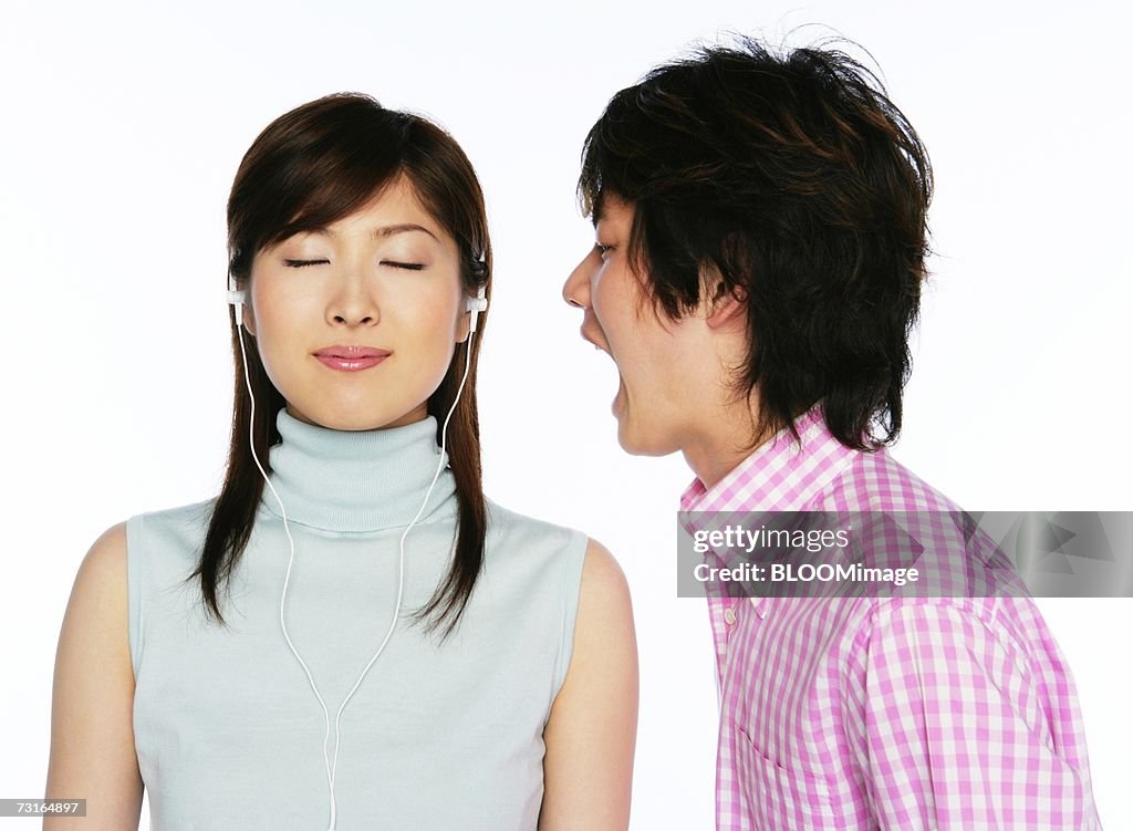 Man crying against woman with head phone