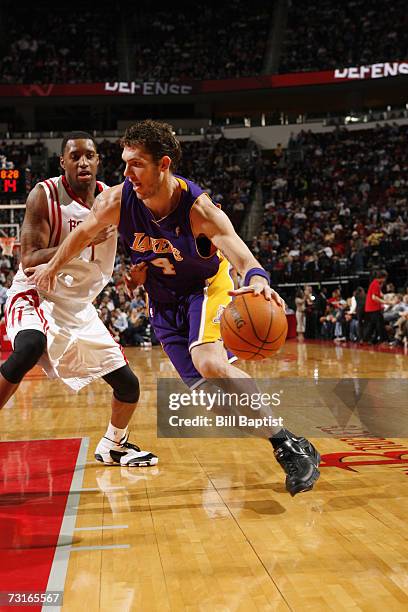 Luke Walton of the Los Angeles Lakers drives to the basket around Tracy McGrady of the Houston Rockets during a game at the Toyota Center on January...