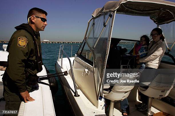 Border Patrol agent Alex Rodriguez rides in a Monroe County Sheriff Marine Unit boat as they pull up to a boat to look for possible human smugglers...