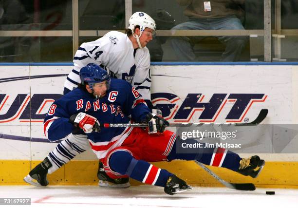 Jaromir Jagr of the New York Rangers is tripped up by Matt Stajan of the Toronto Maple Leafs during the first period of the game on January 31, 2007...