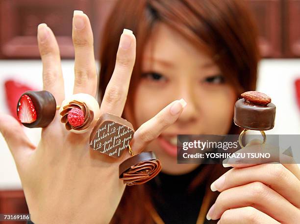 Nami Saeki, a sales clerk of Japan's accessory shop Q-pot shows off assorted chocolate-like creation rings, priced 3,780 yen and 4,200 yen , at...