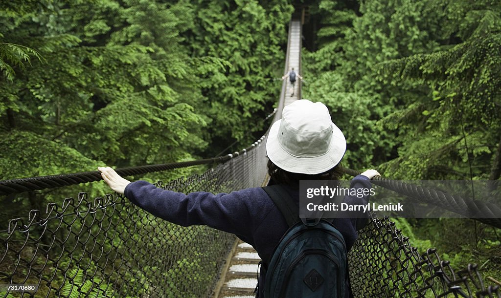 Couple crossing suspension bridge, Vancouver, British Columbia, Canada
