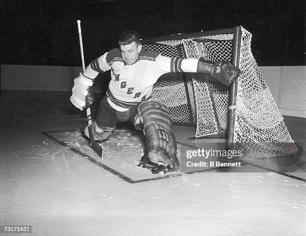 Canadian ice hockey player Lorne 'Gump' Worsley , goalkeeper for the New York Rangers, makes a save, late 1950s or early 1960s.