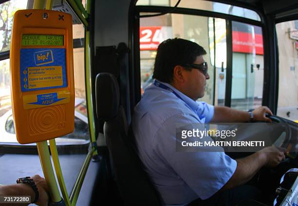 Un chofer conduce uno de los modernos buses del nuevo programa del gobierno denominado "Transantiago" y a su lado se observa el dispositivo...