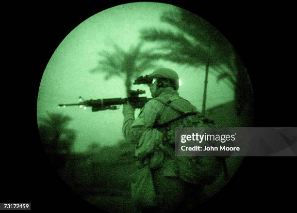 Marine uses night vision goggles while on a search operation in the early hours of February 1, 2007 in Ramadi in Iraq's Anbar province. American...