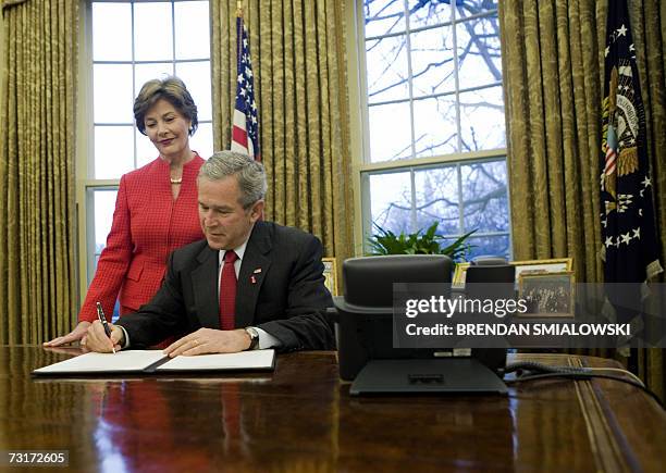 Washington, UNITED STATES: US First Lady Laura Bush watches US President George W. Bush sign a Presidential Proclamation in the Oval Office of the...