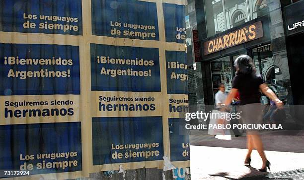 Una mujer pasa junto a carteles alusivos al conflicto entre Uruguay y Argentina por la instalacion de una planta de celulosa en la margen de un rio...