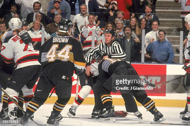 American ice hockey linesman Pat Dapuzzo breaks up a fight during a game between the New Jersey Devils and the Pittsburgh Penguins, January 1998.