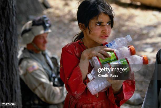 This girl collects plastic bottles thrown away by the American soldiers on July, 2004 in Afghanistan.