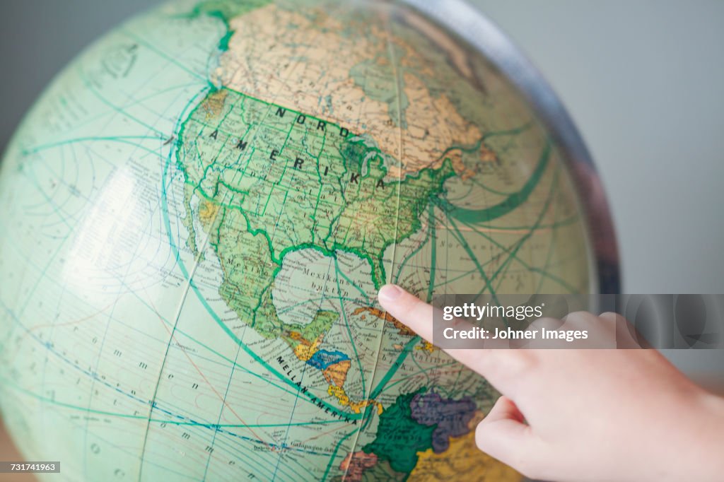 Boy pointing at globe