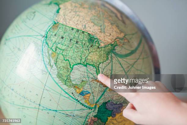 boy pointing at globe - continente americano foto e immagini stock